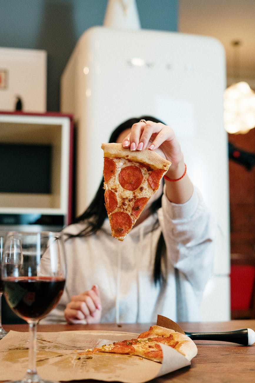 Person Holding Sliced Of Pizza
